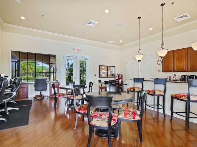 dining room with crown molding, dark wood-type flooring, and french doors