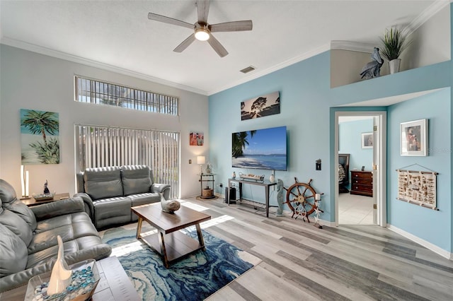 living room featuring a towering ceiling, light hardwood / wood-style floors, ceiling fan, and ornamental molding