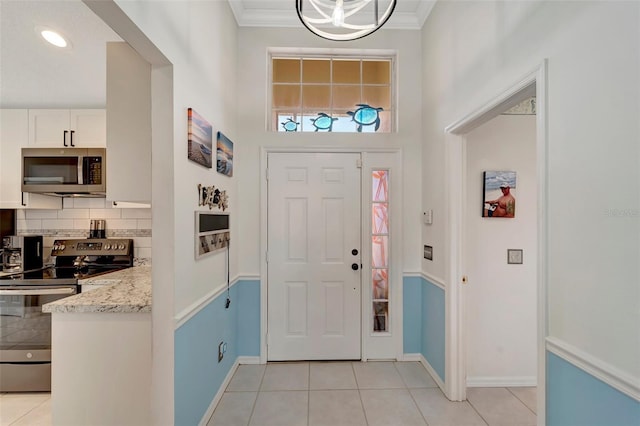 tiled entrance foyer featuring crown molding