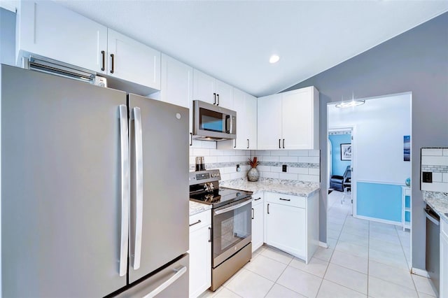 kitchen with white cabinets, vaulted ceiling, and appliances with stainless steel finishes