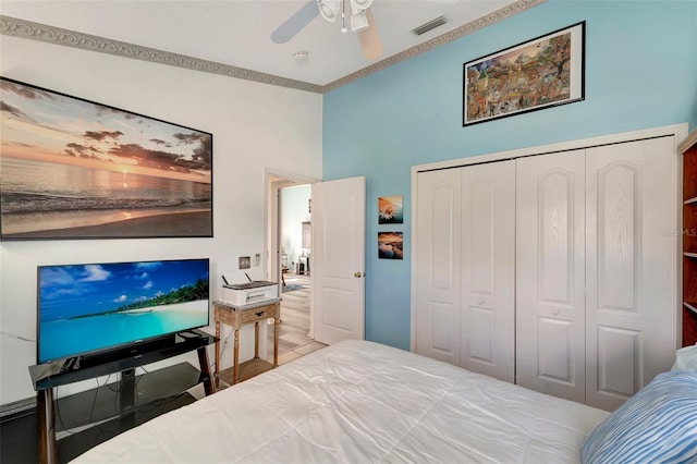 bedroom featuring a closet, ceiling fan, and ornamental molding