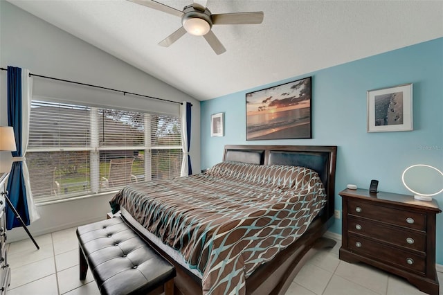 bedroom with a textured ceiling, vaulted ceiling, ceiling fan, and light tile patterned flooring