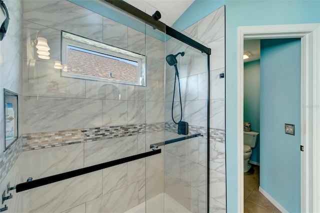 bathroom with tile patterned flooring, toilet, and walk in shower