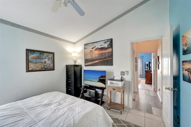 bedroom featuring ceiling fan, light hardwood / wood-style floors, vaulted ceiling, and ornamental molding