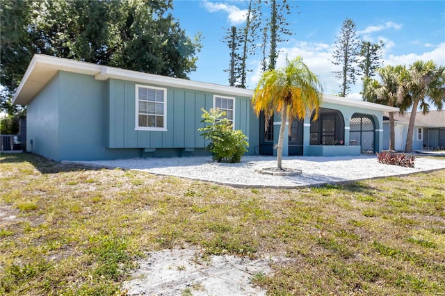 ranch-style house with a front yard and central air condition unit