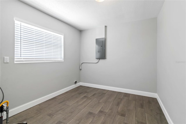 laundry room featuring electric panel, dark hardwood / wood-style floors, and a textured ceiling