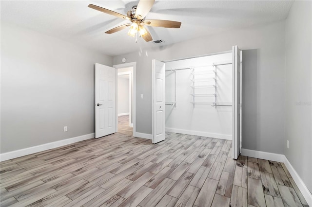 unfurnished bedroom with light hardwood / wood-style flooring, a textured ceiling, a closet, and ceiling fan