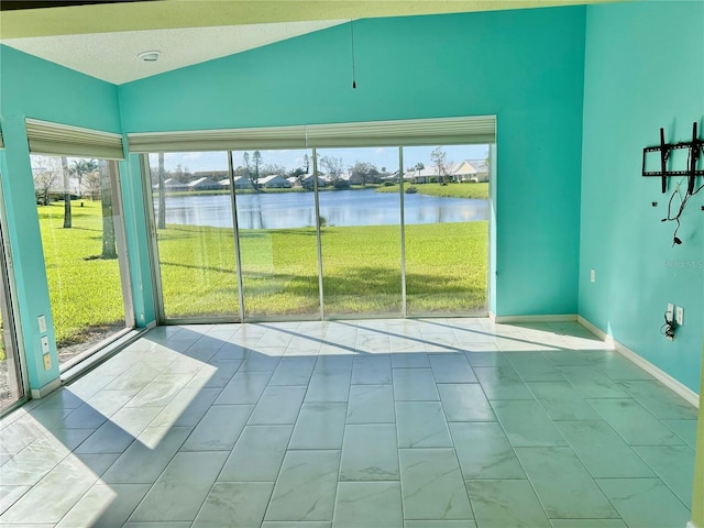 unfurnished sunroom with plenty of natural light, a water view, and vaulted ceiling