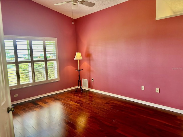 unfurnished room with a textured ceiling, ceiling fan, and dark hardwood / wood-style flooring