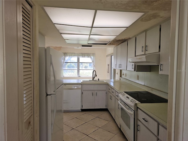 kitchen featuring white appliances, light tile patterned floors, sink, and white cabinets