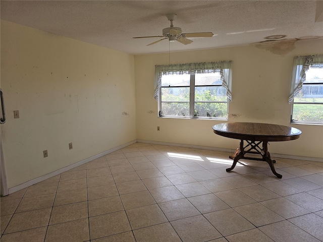 tiled empty room featuring a textured ceiling and ceiling fan