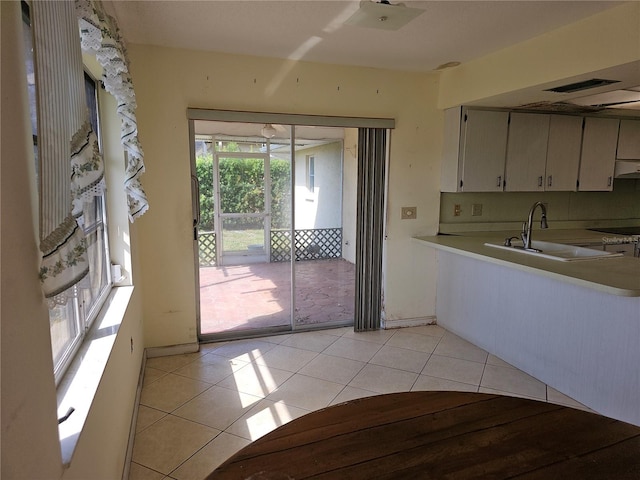 kitchen featuring light tile patterned floors, sink, and ventilation hood