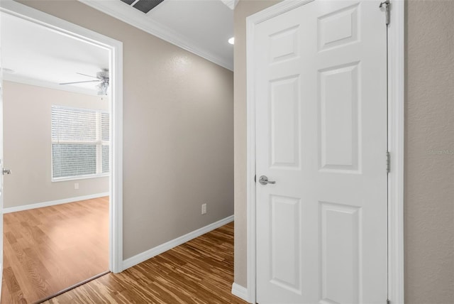 hallway featuring ornamental molding and hardwood / wood-style floors