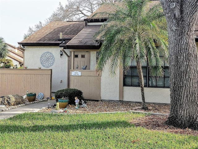 5650 Mashie Cir, North Port, FL 34287 - view of exterior entry featuring stucco siding and roof with shingles