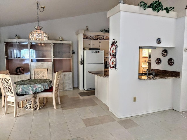 dining space with lofted ceiling and light tile patterned floors