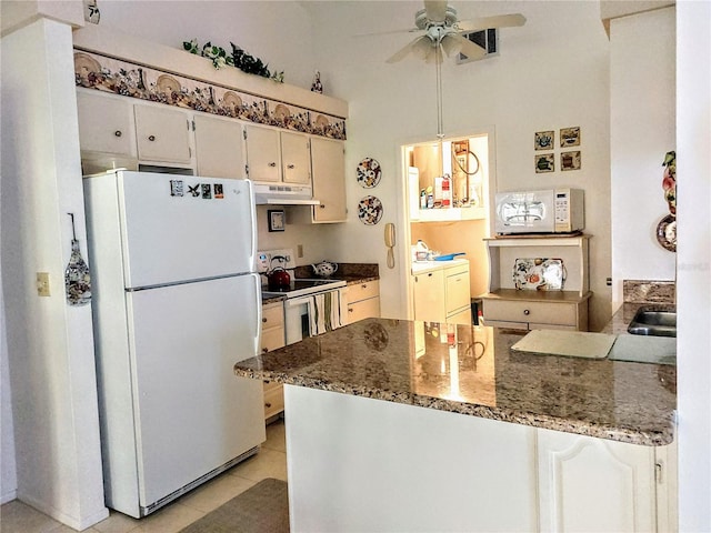 kitchen featuring ceiling fan, white appliances, dark stone countertops, and light tile patterned flooring