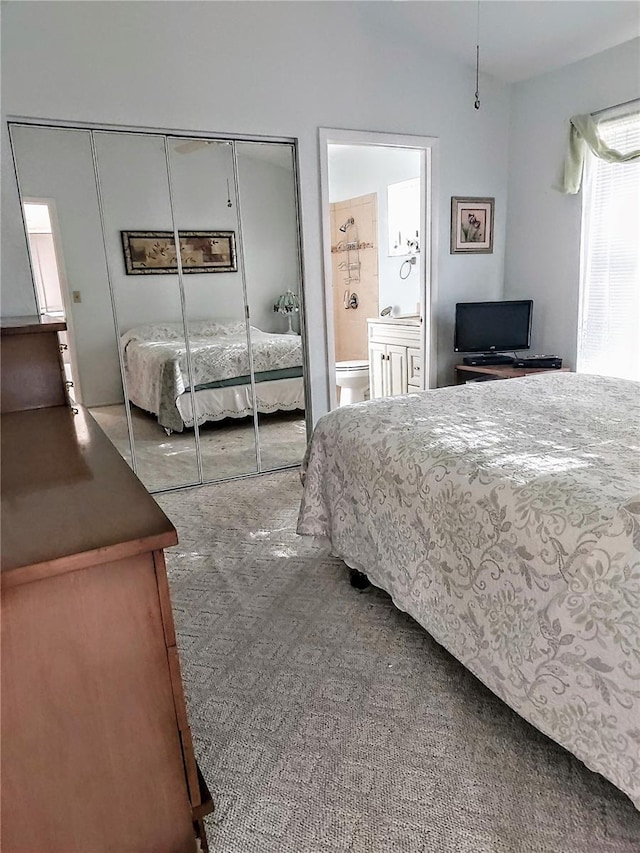 carpeted bedroom featuring a closet and connected bathroom