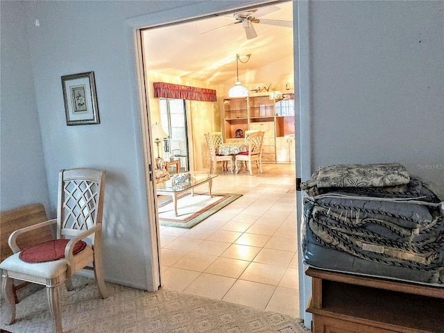 living area featuring ceiling fan, tile patterned flooring, and vaulted ceiling