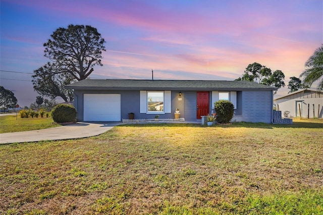 ranch-style home with a yard and a garage