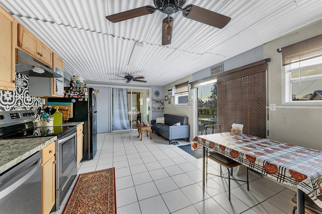 interior space with a wealth of natural light, appliances with stainless steel finishes, light brown cabinetry, and light tile patterned floors