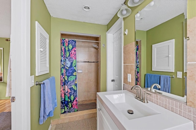 bathroom featuring vanity, tile patterned floors, walk in shower, and a textured ceiling