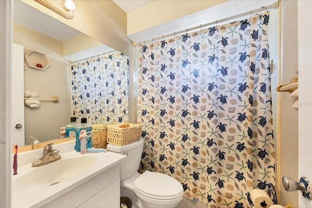 bathroom with toilet, vanity, and a shower with shower curtain