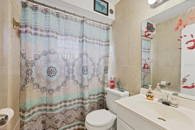 bathroom with tile walls, vanity, toilet, and walk in shower