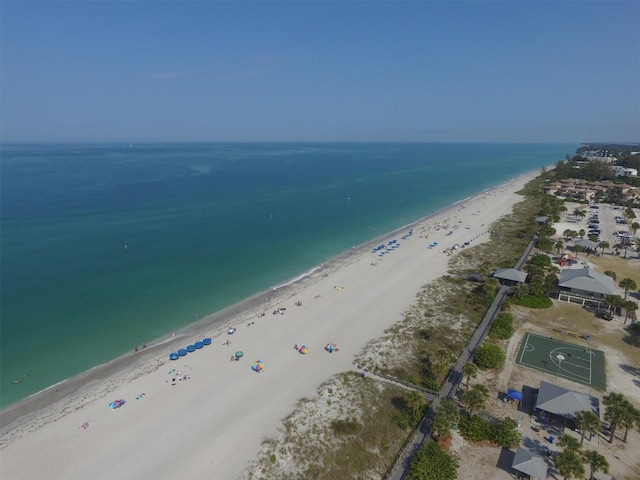 drone / aerial view with a water view and a beach view