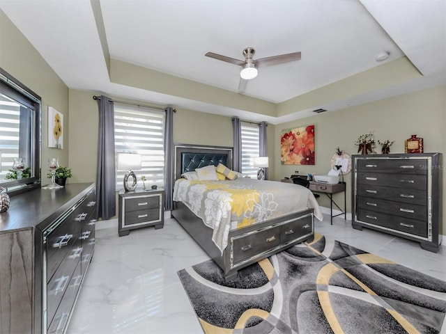 bedroom featuring ceiling fan and a raised ceiling