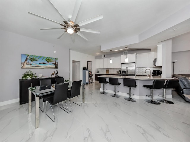 dining area featuring ceiling fan and sink