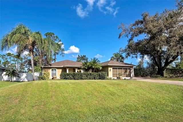 ranch-style home with a front yard and a sunroom