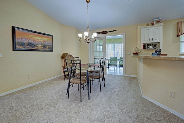 carpeted dining area featuring a chandelier