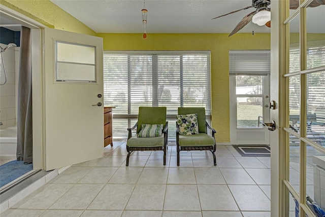 sunroom / solarium featuring french doors and ceiling fan