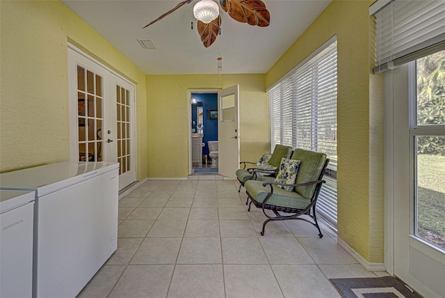 sunroom featuring independent washer and dryer, a healthy amount of sunlight, and ceiling fan