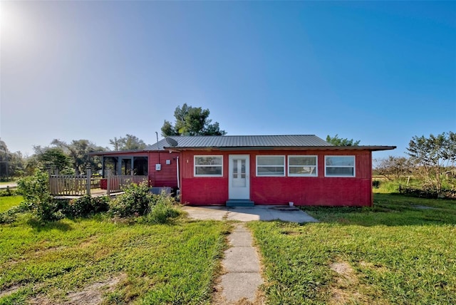 ranch-style home with a wooden deck and a front yard