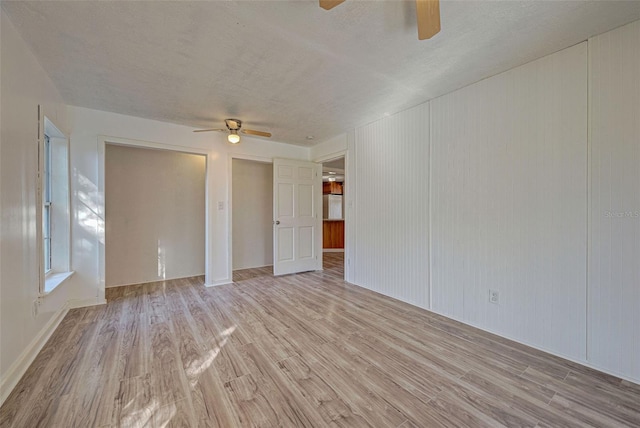 empty room featuring ceiling fan, a textured ceiling, and light hardwood / wood-style flooring