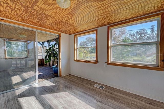 spare room with hardwood / wood-style flooring, wooden ceiling, and plenty of natural light