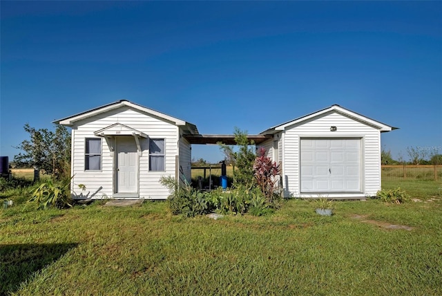 exterior space featuring a garage, a yard, and an outbuilding