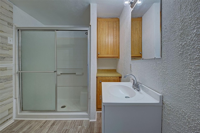 bathroom featuring vanity, hardwood / wood-style flooring, and a shower with shower door