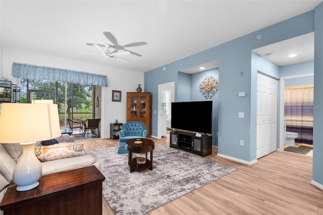 living room with light hardwood / wood-style floors and ceiling fan