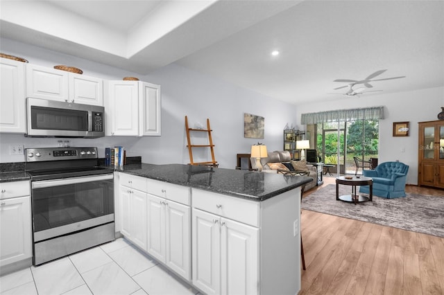 kitchen featuring appliances with stainless steel finishes, light wood-type flooring, kitchen peninsula, ceiling fan, and white cabinets