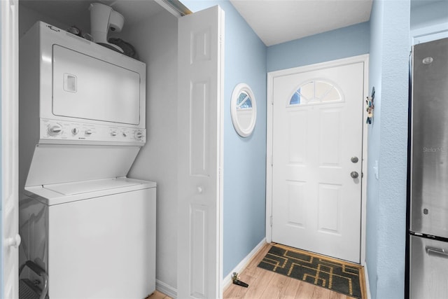 laundry area with hardwood / wood-style flooring and stacked washer and dryer