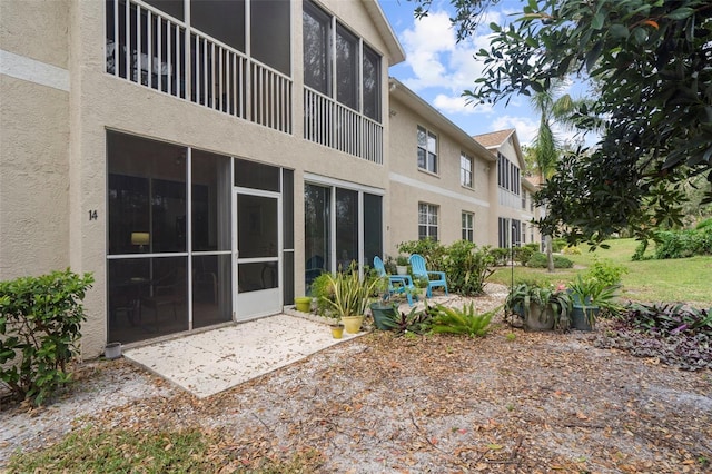 back of property with a patio area and a sunroom