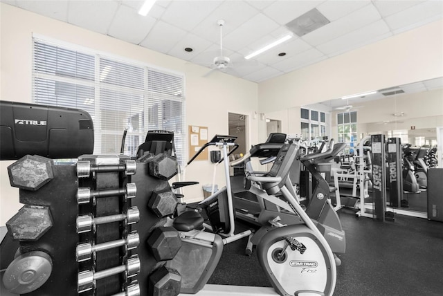 exercise room with ceiling fan and a drop ceiling