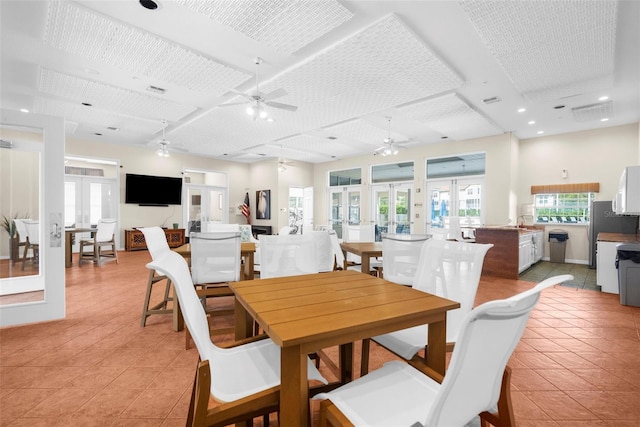 tiled dining space featuring french doors and ceiling fan