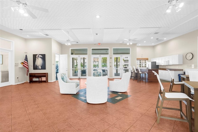 living room featuring french doors, ceiling fan, a textured ceiling, and light tile patterned floors