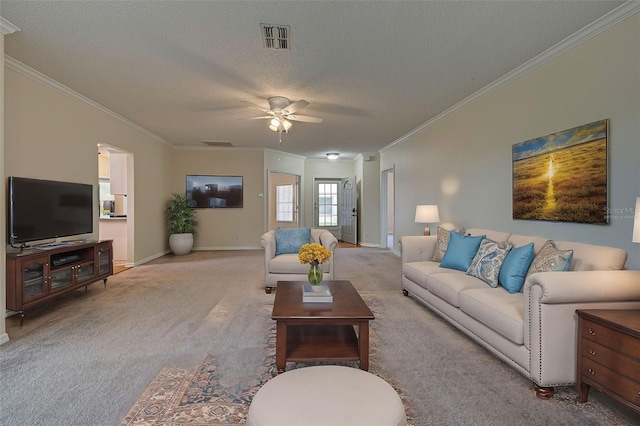 living room featuring ceiling fan, carpet, a textured ceiling, and ornamental molding