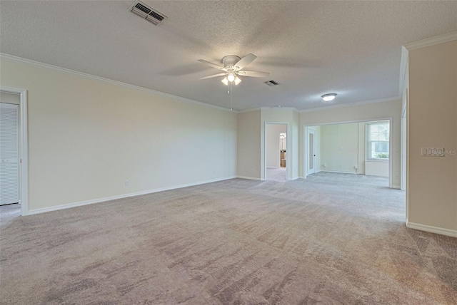 unfurnished room featuring light carpet, a textured ceiling, and ornamental molding