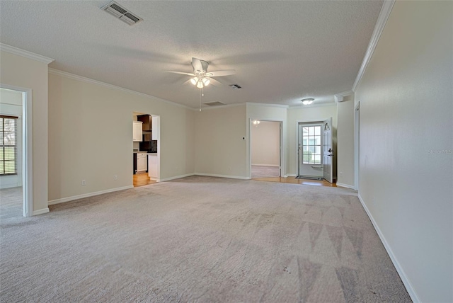 carpeted empty room featuring a textured ceiling, crown molding, ceiling fan, and a healthy amount of sunlight