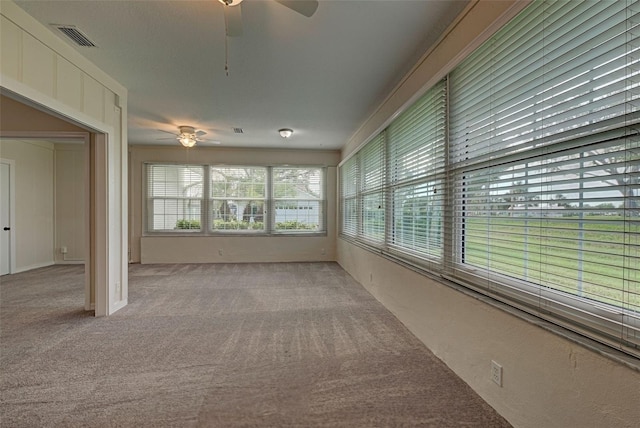 unfurnished sunroom with ceiling fan